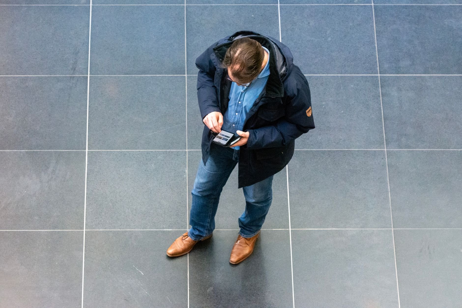 Casually dressed tradesperson checking his phone — service businesses need sites that drive calls.