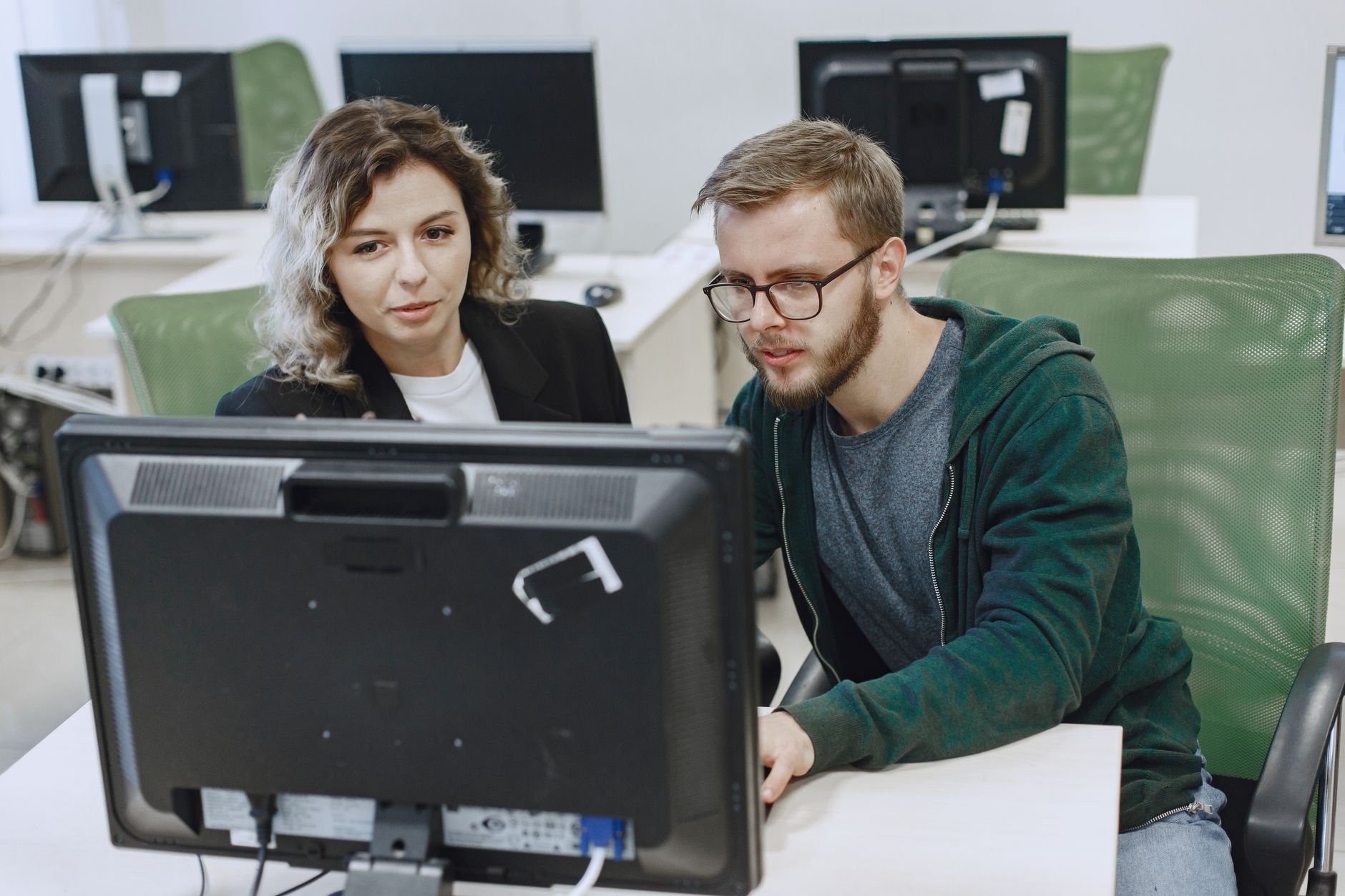 Two colleagues working together at a computer reviewing a website — hands-on support from a local team.